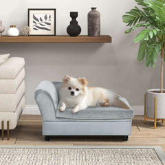 Small dog lounging on a luxury gray foam couch dog bed with hidden storage, modern pet furniture.
